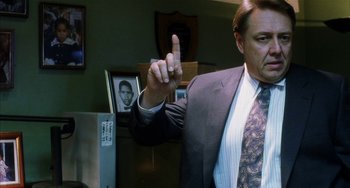 Movie still from “Narc” (2002), directed by Joe Carnahan – A man in a suit and tie holding up a finger; Close Up shot, Low angle