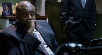 Movie still from “Narc” (2002), directed by Joe Carnahan – A man in a business suit sitting in front of a desk; Close Up shot, High angle