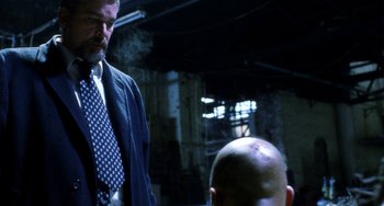 Movie still from “Narc” (2002), directed by Joe Carnahan – A man wearing a suit and tie standing next to a bald man; Medium shot, Low angle