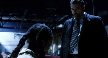 Movie still from “Narc” (2002), directed by Joe Carnahan – A man in a suit and tie standing next to another man; Medium shot, Low angle