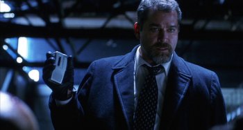 Movie still from “Narc” (2002), directed by Joe Carnahan – A man in a suit and tie holding a cell phone; Close Up shot, Low angle