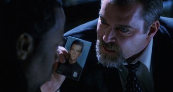 Movie still from “Narc” (2002), directed by Joe Carnahan – A man holding up a picture of himself; Close Up shot, Over the shoulder angle