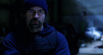 Movie still from “Narc” (2002), directed by Joe Carnahan – A man with a beard wearing a blue hat and jacket; Close Up shot, Over the shoulder angle
