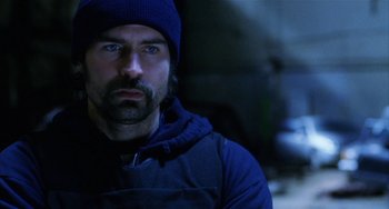 Movie still from “Narc” (2002), directed by Joe Carnahan – A man with a beard wearing a blue hat and jacket; Close Up shot, Low angle