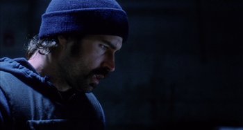 Movie still from “Narc” (2002), directed by Joe Carnahan – A man with a beard and a blue hat; Close Up shot, Low angle
