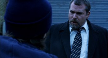 Movie still from “Narc” (2002), directed by Joe Carnahan – A man in a suit and tie talking to another man in a hat; Close Up shot, Over the shoulder angle