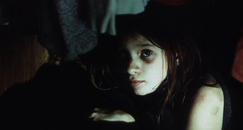 Movie still from “Narc” (2002), directed by Joe Carnahan – A young girl with long dark hair wearing a black hat; Close Up shot, High angle
