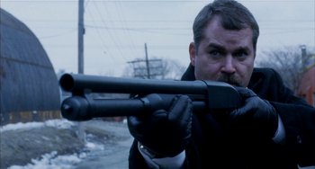 Movie still from “Narc” (2002), directed by Joe Carnahan – A man is holding a rifle and aiming it; Close Up shot, Over the shoulder angle
