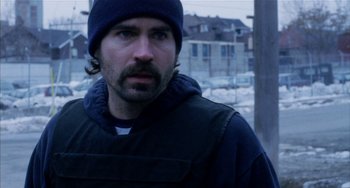 Movie still from “Narc” (2002), directed by Joe Carnahan – A person wearing a jacket and a hat; Close Up shot, Over the shoulder angle