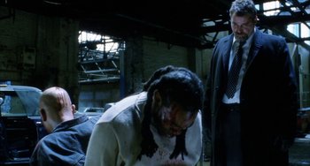 Movie still from “Narc” (2002), directed by Joe Carnahan – A man in a white shirt and a man in a black suit; Medium shot, Over the shoulder angle