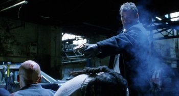 Movie still from “Narc” (2002), directed by Joe Carnahan – A man is holding a knife in his hand; Medium shot, Low angle