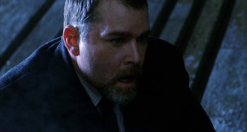 Movie still from “Narc” (2002), directed by Joe Carnahan – A person wearing a suit and tie; Close Up shot, Low angle