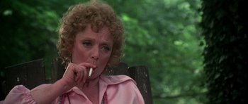Movie still from “Nashville” (1975), directed by Robert Altman – A person sitting on a chair smoking a cigarette; Close Up shot, Low angle