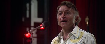 Movie still from “Nashville” (1975), directed by Robert Altman – An older man is speaking into a microphone; Close Up shot, Low angle