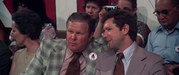 Movie still from “Nashville” (1975), directed by Robert Altman – Two men in suits and ties sitting next to each other; Close Up shot, Over the shoulder angle