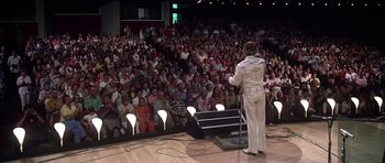 Movie still from “Nashville” (1975), directed by Robert Altman – A man in a white suit standing in front of an audience; Wide shot, High angle