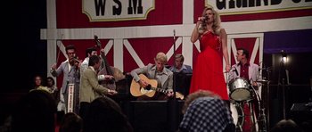 Movie still from “Nashville” (1975), directed by Robert Altman – A woman in a red dress singing while a man plays a guitar; Wide shot, Low angle