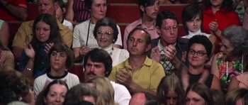 Movie still from “Nashville” (1975), directed by Robert Altman – A group of people sitting and standing in a room; Medium shot, High angle