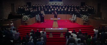 Movie still from “Nashville” (1975), directed by Robert Altman – A man standing in front of an audience in front of a microphone; Extreme Wide shot, High angle
