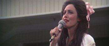 Movie still from “Nashville” (1975), directed by Robert Altman – A woman holding a microphone up to her mouth; Close Up shot, Low angle
