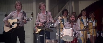 Movie still from “Nashville” (1975), directed by Robert Altman – A group of men playing musical instruments on a porch; Medium shot, Low angle