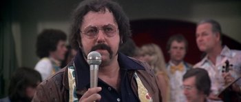 Movie still from “Nashville” (1975), directed by Robert Altman – A man with a microphone in his hand; Close Up shot, Low angle