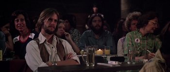 Movie still from “Nashville” (1975), directed by Robert Altman – A group of people sitting at a table with drinks; Medium shot, Over the shoulder angle