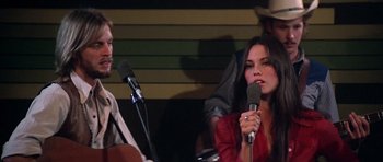 Movie still from “Nashville” (1975), directed by Robert Altman – A woman holding a microphone and a man holding a microphone; Close Up shot, Over the shoulder angle