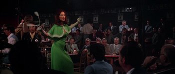 Movie still from “Nashville” (1975), directed by Robert Altman – A woman in a green dress is performing in front of an audience; Wide shot, Low angle
