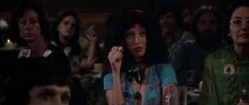 Movie still from “Nashville” (1975), directed by Robert Altman – A woman smoking a cigarette in front of other people; Close Up shot, Over the shoulder angle