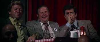 Movie still from “Nashville” (1975), directed by Robert Altman – Two men sitting at a table and one of the men is laughing; Medium shot, Over the shoulder angle