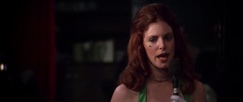 Movie still from “Nashville” (1975), directed by Robert Altman – A woman with red hair and a green dress is singing; Close Up shot, Low angle