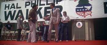 Movie still from “Nashville” (1975), directed by Robert Altman – A man in a suit and tie shaking hands with another man in a suit and tie; Wide shot, Low angle