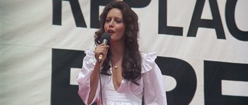 Movie still from “Nashville” (1975), directed by Robert Altman – A woman in a white dress is holding a microphone; Medium shot, Low angle