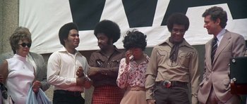 Movie still from “Nashville” (1975), directed by Robert Altman – A group of people standing next to each other on a stage; Medium shot, Low angle