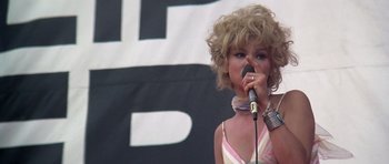 Movie still from “Nashville” (1975), directed by Robert Altman – A woman with blonde curly hair is holding a microphone; Close Up shot, Low angle