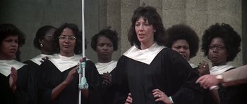 Movie still from “Nashville” (1975), directed by Robert Altman – A group of women in black robes holding a microphone; Medium shot, Low angle