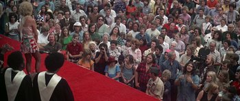 Movie still from “Nashville” (1975), directed by Robert Altman – A crowd of people sitting on a red carpet; Wide shot, High angle
