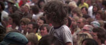 Movie still from “Nashville” (1975), directed by Robert Altman – A young child is standing in a crowd of people; Medium shot, High angle