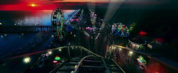 Movie still from “National Champions” (2021), directed by Ric Roman Waugh – A view of a roller - coaster ride at night; Extreme Wide shot, High angle