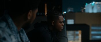 Movie still from “National Champions” (2021), directed by Ric Roman Waugh – A man sitting in front of another man in a car at night; Close Up shot, Over the shoulder angle