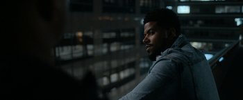 Movie still from “National Champions” (2021), directed by Ric Roman Waugh – A man with a beard is looking out of a window; Close Up shot, Over the shoulder angle