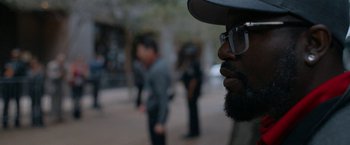 Movie still from “National Champions” (2021), directed by Ric Roman Waugh – A person wearing a hat and glasses; Close Up shot, Over the shoulder angle