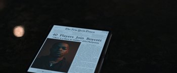 Movie still from “National Champions” (2021), directed by Ric Roman Waugh – The front page of the new york times; Extreme Close Up shot, High angle