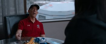 Movie still from “National Champions” (2021), directed by Ric Roman Waugh – An older man sitting at a table in front of a window; Close Up shot, Over the shoulder angle