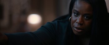 Movie still from “National Champions” (2021), directed by Ric Roman Waugh – A woman's face in a dark room; Close Up shot, Over the shoulder angle