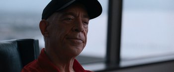 Movie still from “National Champions” (2021), directed by Ric Roman Waugh – An older man wearing a baseball cap and a red shirt; Close Up shot, Low angle