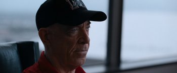 Movie still from “National Champions” (2021), directed by Ric Roman Waugh – An older man wearing a baseball cap looking to his left; Close Up shot, Over the shoulder angle