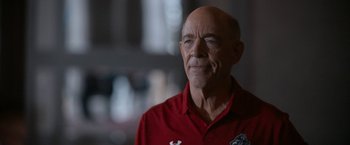 Movie still from “National Champions” (2021), directed by Ric Roman Waugh – An older man in a red shirt is looking into the distance; Close Up shot, Low angle