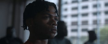 Movie still from “National Champions” (2021), directed by Ric Roman Waugh – A person with dreadlocks; Close Up shot, Low angle